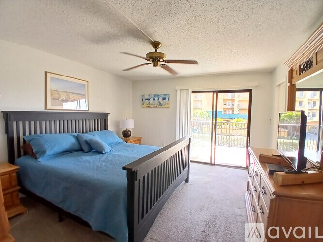 A bedroom with a bed, dresser, and sliding glass doors.