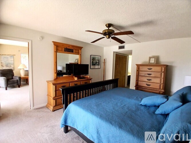 A bedroom with a bed, dresser, and mirror.
