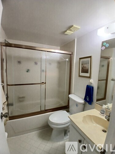 A bathroom with a toilet, sink, and shower.