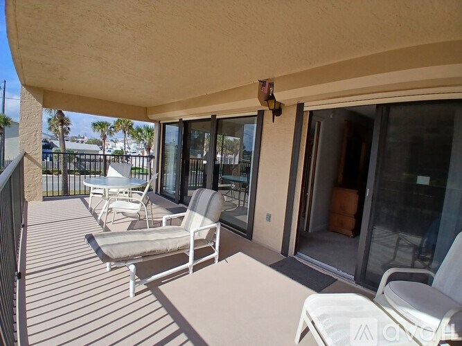 A patio with white chairs and a table is shown.