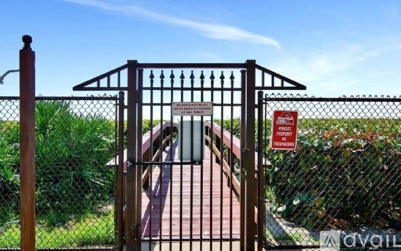A gate with a sign that says "No Trespassing" is blocking a path.