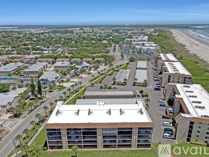 A bird's eye view of a coastal town with buildings, roads, and a beach.