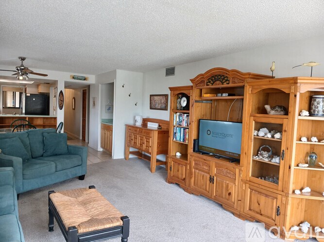 A living room with a green couch and a wooden entertainment center.