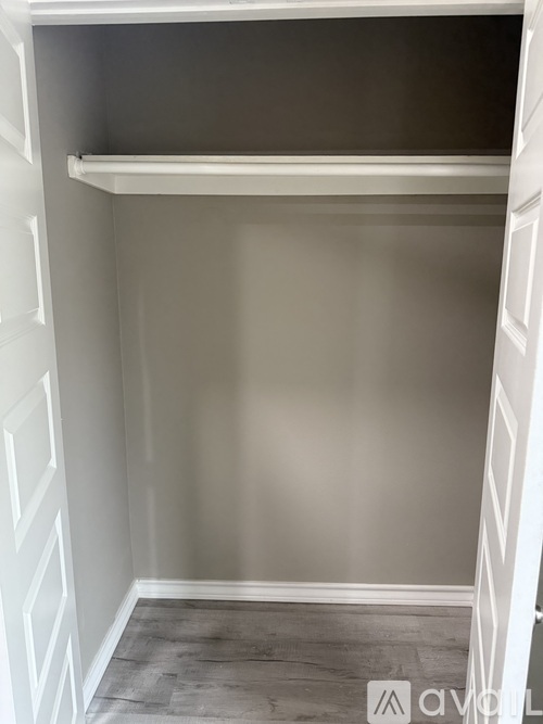 A white closet with a shelf and a grey floor.