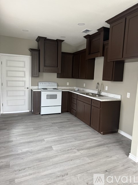 A kitchen with brown cabinets and a white stove.