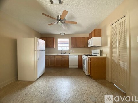 A kitchen with white appliances and wooden cabinets.