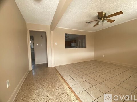 A room with a ceiling fan and tile flooring.