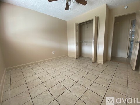 A room with a ceiling fan and tile flooring.
