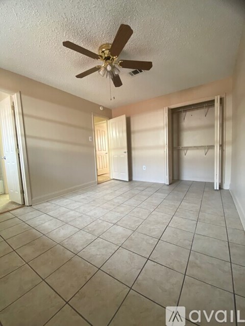 A room with a ceiling fan and tile flooring.