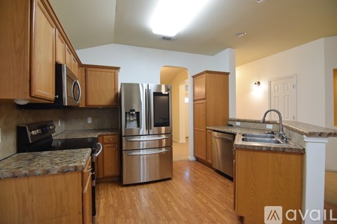 A kitchen with wooden cabinets and stainless steel appliances.