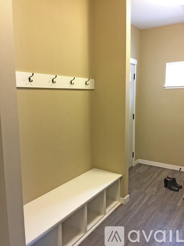 A hallway with a bench and coat hooks.