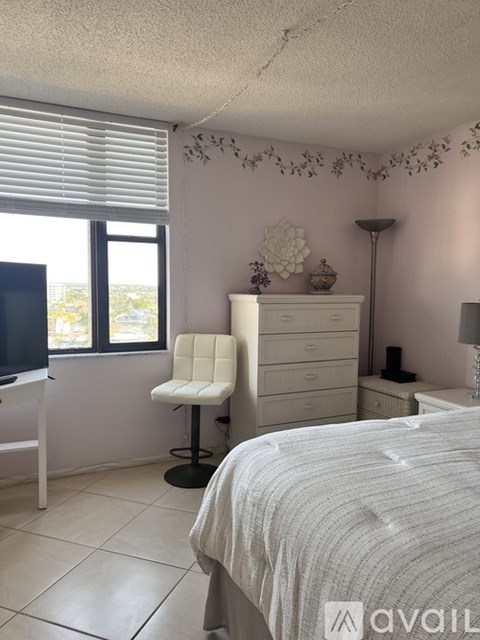 A bedroom with a bed, chair, and dresser.