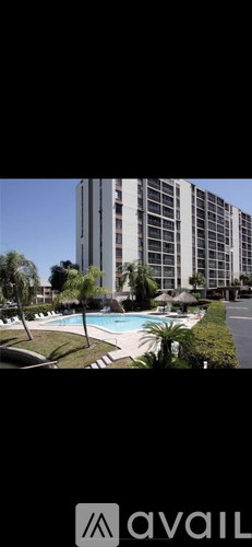 A tall building with a pool in front of it.
