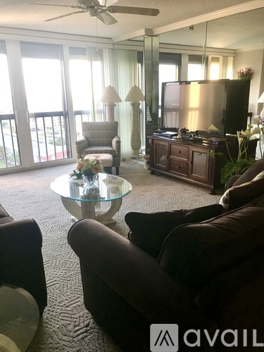 A living room with a glass coffee table and a television.
