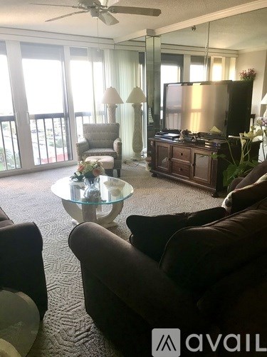 A living room with a glass coffee table and a television.
