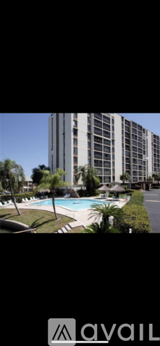 A tall building with a pool in front.