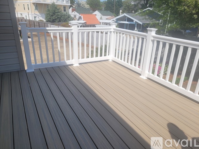 A deck with white railings and a shadow of a person on the floor.