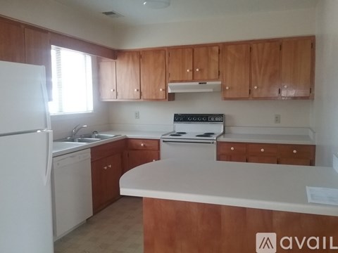 A kitchen with wooden cabinets and a white refrigerator.