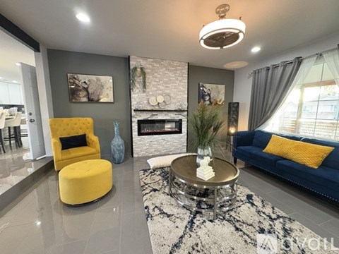 A living room with a yellow chair and a blue couch.