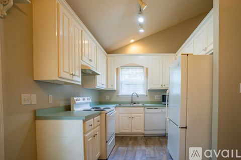 A kitchen with white cabinets and a green countertop.