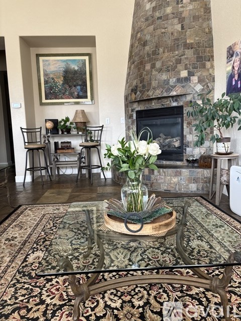 A living room with a fireplace and a painting on the wall.