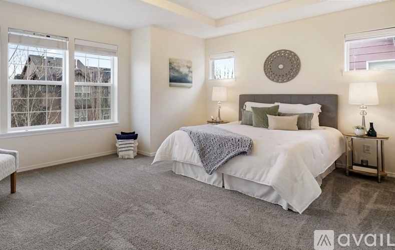 A bedroom with a large bed and two lamps.