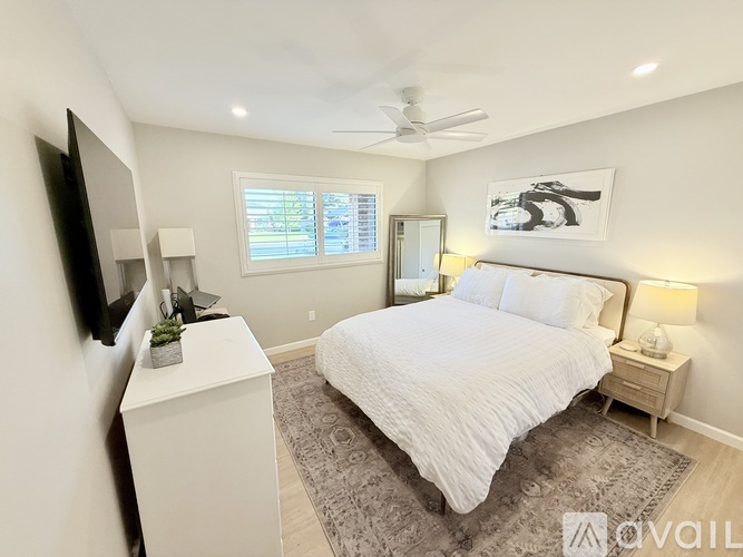 A bedroom with a bed, nightstand, and television.