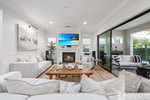 A modern living room with a fireplace and a painting on the wall.
