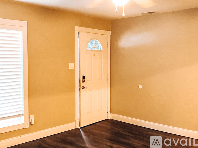A room with a white door and a window with blinds.