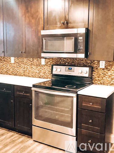 A modern kitchen with a stove top oven and microwave above it.
