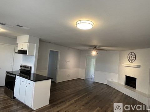 A modern kitchen with white cabinets and a black countertop.