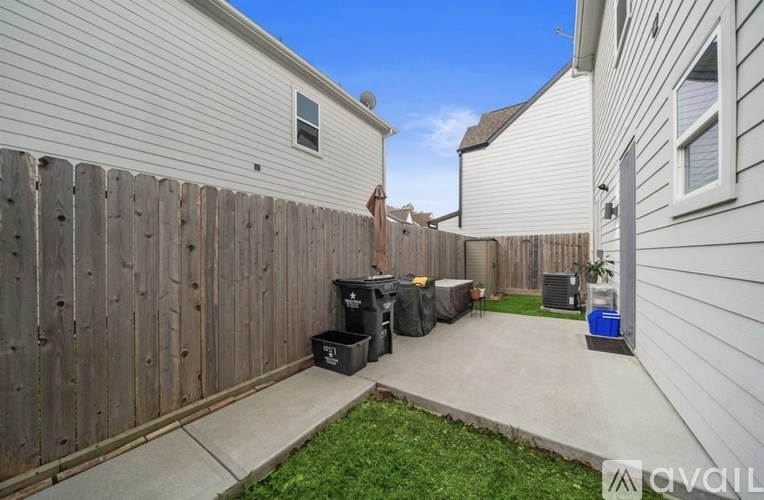 A backyard with a wooden fence and a green lawn.