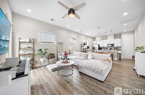 A spacious living room with a white sofa set and a coffee table.