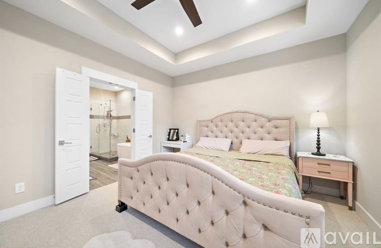 A bedroom with a large bed, a dresser, and a ceiling fan.