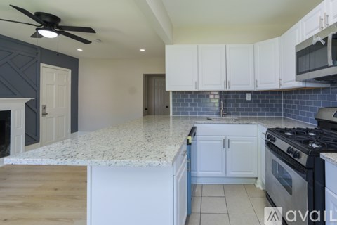 A kitchen with a white countertop and a black stove top oven.