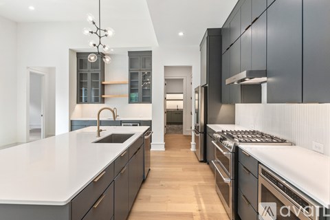 A modern kitchen with dark cabinets and a white countertop.