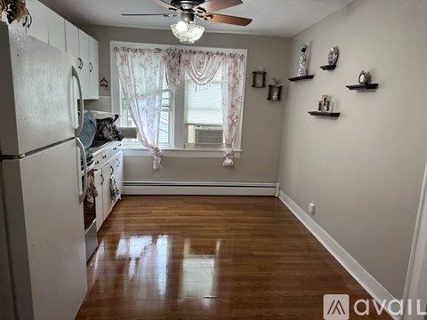 A kitchen with a white refrigerator and wooden floors.