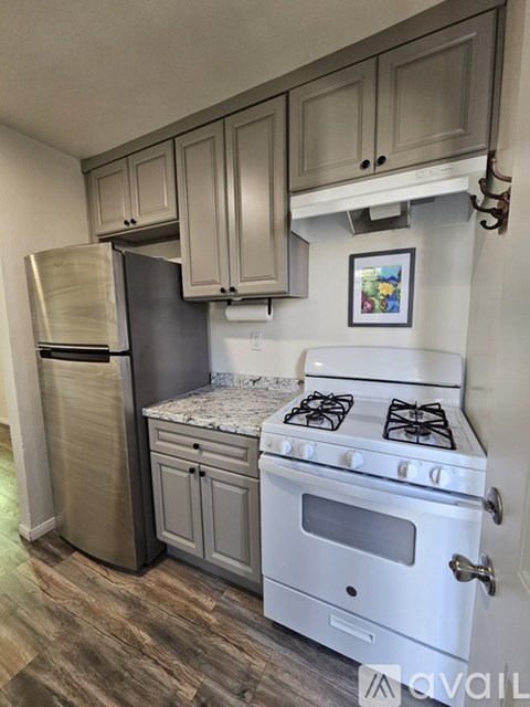 A kitchen with a white stove and a fridge.