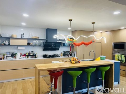 A kitchen with a wooden table and bar stools.