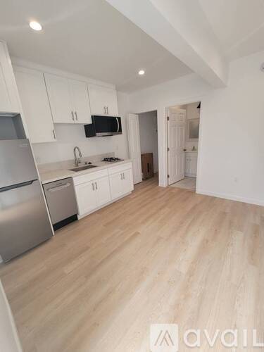 A kitchen with wooden floors and white cabinets.