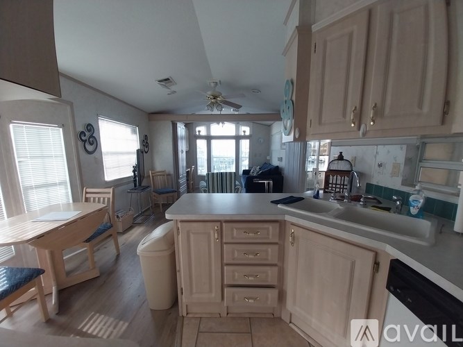 A kitchen with wooden cabinets and a large island in the middle.