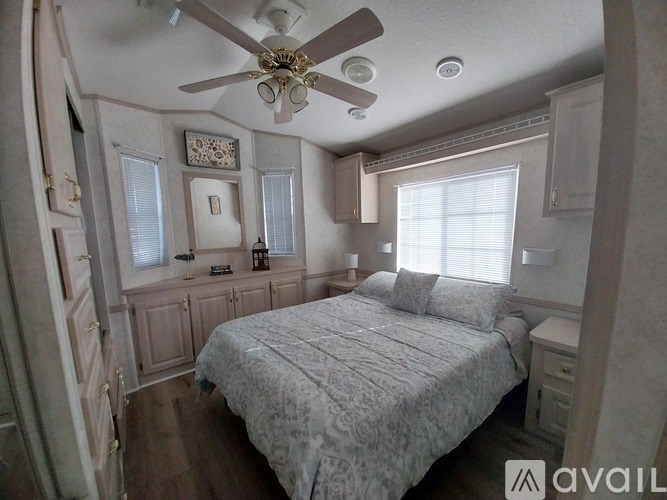 A bedroom with a bed, dresser, and ceiling fan.