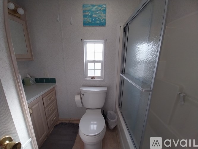 A small bathroom with a toilet, sink, and shower.