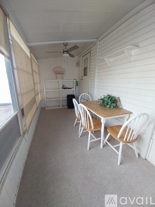 A room with a table and chairs and a ceiling fan.