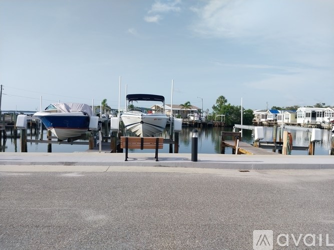 A boat is docked at a marina with a bench in front of it.