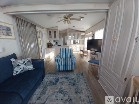 A living room with a blue couch and a striped armchair.