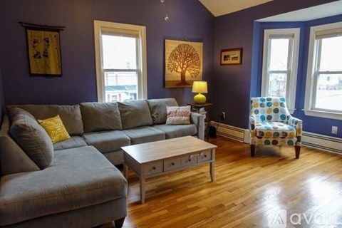 A living room with a grey couch and a wooden coffee table.