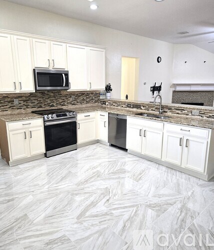 A kitchen with white cabinets and a patterned floor.