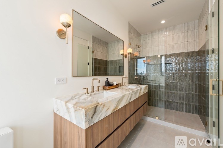 A bathroom with a marble countertop and a large mirror.