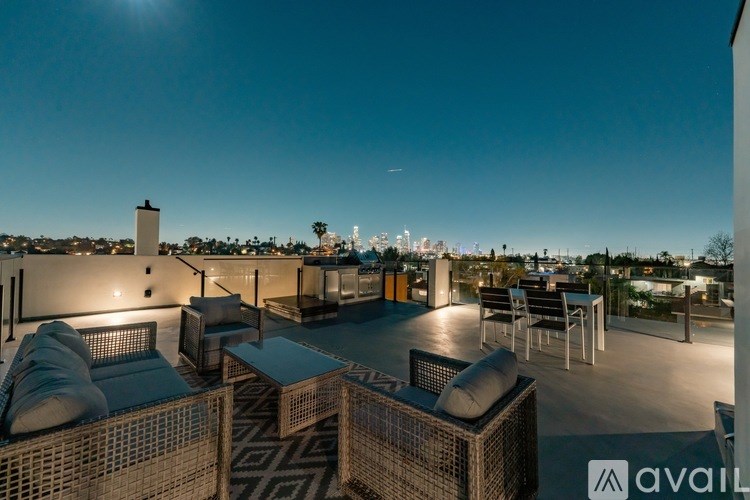 A rooftop patio with a view of the city at night.
